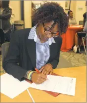  ??  ?? Waldorf resident Jordan Mitchell, 17, fills out a Charles County Public Library job applicatio­n at the Young Adult Job Fair on March 22.