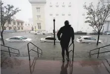  ?? Gerald Herbert / Associated Press ?? A man watches rising water pushed by Hurricane Sally swamp cars and trucks on a downtown Pensacola, Fla., street.