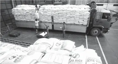  ??  ?? FRESH BATCH – Workers unload sacks of rice at the National Food Authority (NFA) warehouse on Visayas Avenue, Quezon City, yesterday as the new buffer stock from Vietnam and Thailand arrives. The newly delivered rice will be distribute­d to selected...