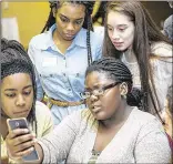  ??  ?? Inlet Grove High School’s Brianna Luberisse (with phone) leads her classmates in a fake news quiz during the event at the Embassy Suites in West Palm Beach. From left: Tatyana Moise, Kalayah Samuels and Yorgelis Yambo.