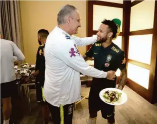  ?? Lucas Figueiredo/cbf ?? Após se apresentar, Neymar é abraçado pelo técnico Tite durante almoço no hotel da seleção brasileira; sem jogar no PSG, atacante vai defender o Brasil