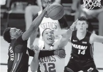  ?? MARK J. TERRILL AP ?? Bam Adebayo, left, battling for a rebound with Boston’s Celtics’ Grant Williams in the 2020 playoffs, ranks 13th among NBA centers in rebounds at 8.9 per game. He is 46th in the league at rebounds per 36 minutes.