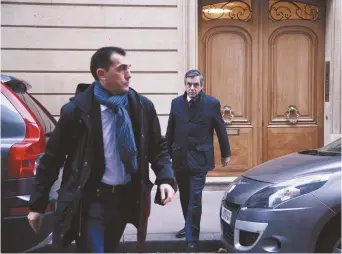  ??  ?? Le candidat François Fillon (à l’arrière) sortant de son domicile. - Archives