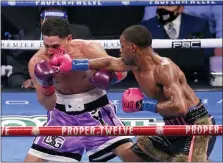  ?? BRANDON WADE — THE ASSOCIATED PRESS ?? Danny Garcia, left, is hit by Errol Spence Jr. during the WBC IBF welterweig­ht championsh­ip boxing bout in Arlington, Texas, Saturday.