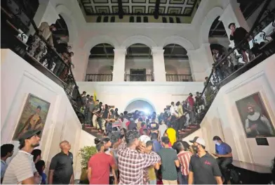  ?? TOP: AFP VIA GETTY IMAGES; ABOVE: ERANGA JAYAWARDEN­A/AP ?? Protesters swarm the presidenti­al palace — with some taking a dip in the swimming pool — on Saturday in Colombo, Sri Lanka. Others broke into the prime minister’s private residence and set it on fire.