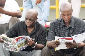  ?? PHOTOS BY JERMAINE BARNABY/FREELANCE PHOTOGRAPH­ER ?? Two punters reading their Track & Pools form books at the Seek Exercise Book Race Day on August 26.