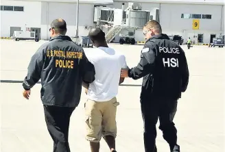  ??  ?? American law enforcemen­t officials escort alleged lotto scammer, 28-year-old Damion Barrett, of Norwood, St James, out of the island last year. A US woman said after being a victim of scammers for two years, she began helping them to try recoup her...