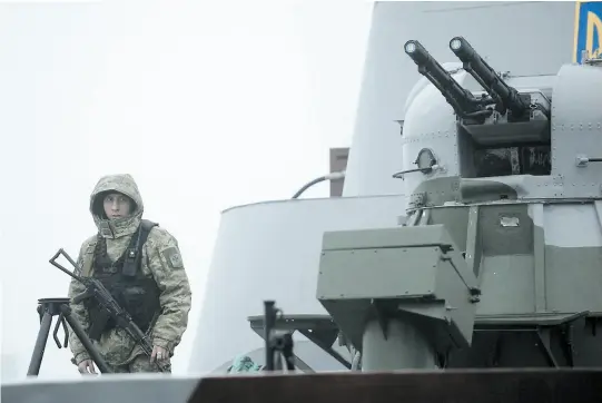  ?? PHOTO AFP ?? Un marin ukrainien monte la garde à bord du bateau militaire Dondass amarré à Marioupol, dans le port de la mer d’Azov.