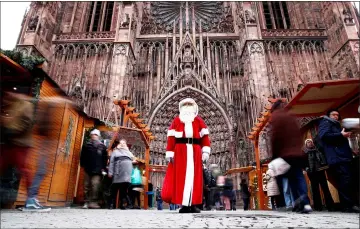  ??  ?? A man dressed as Father Christmas poses outside the Cathedral in Strasbourg. — Reuters photo