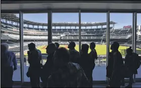  ??  ?? Members of the media look through the glass window from Chop House at the almost-finished SunTrust Park on Wednesday.