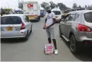  ?? Photograph: Tsvangiray­i Mukwazhi/AP ?? A currency trader counts his money in Harare. Shortages of small US dollar denominati­ons have caused a boom in dealers trading torn notes.