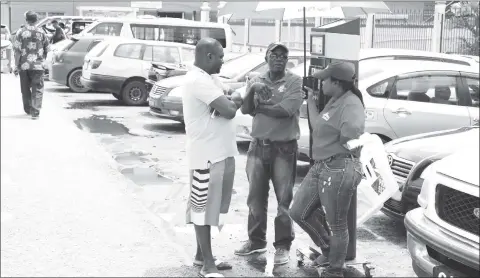  ??  ?? SCS staff interactin­g with a member of the public on the parking meters