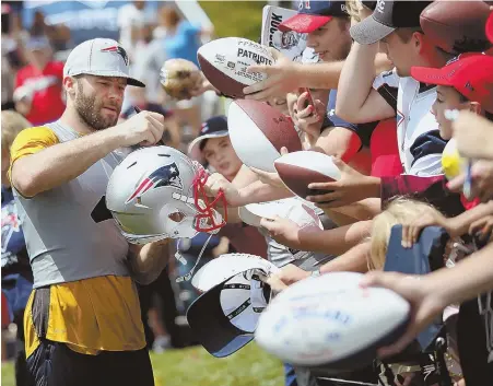  ?? STAFF PHOTOS BY NANCY LANE (ABOVE), CHRIS CHRISTO (BELOW) ?? BIG-NAME ATTRACTION: Julian Edelman signs autographs during the Patriots’ first workout of training camp Thursday at Gillette Stadium.
