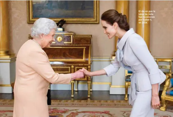  ??  ?? El día en que la labor de Jolie fue reconocida por Isabel II, en 2014.
