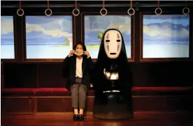  ?? Photograph: Franck Robichon/EPA ?? A Ghibli Park visitor sits next to the No-face (Kao-nashi) character from the movie Spirited Away.