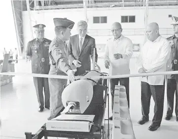  ?? — AFP photo ?? A Philippine airforce officer explains to Lorenzana and Kim (third and fourth right respective­ly) one of the six ScanEagle Unmanned Aerial Vehicles, during the turn-over ceremonies at the military airbase.