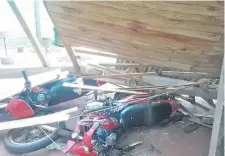  ??  ?? Dos motociclet­as quedaron bajo los restos de una estructura de madera que se cayó durante la tormenta en Natalio.