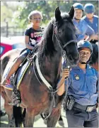  ??  ?? RIDING TALL: Ebongwa Konya, 5, from Motherwell, has a ride on Fay, with Constable Sikhumbuzo Hloyi leading the way