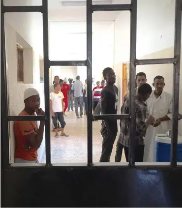  ?? Foto: dpa/Benno Schwingham­mer ?? Hinter Gittern: Migranten in einem Auffanglag­er in Misrata (Libyen)