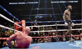  ??  ?? Deontay Wilder a sauvé son titre en envoyant Tyson Fury au tapis dans les dernières secondes du combat. (Photo PQR) finalement au (-).