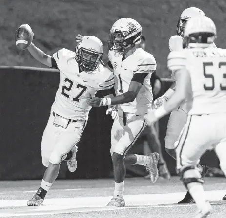  ?? Wilf Thorne / Contributo­r ?? Jersey Village’s Pablo Cuadra Guillen (27) celebrates with teammates after scoring a touchdown Friday night against Cypress Falls.