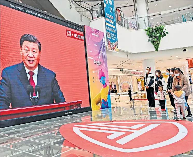  ?? Power play: people at a shopping mall in Qingzhou watch a broadcast by President Xi last weekend; below left, Xi with Li Qiang at the Communist Party Congress ??