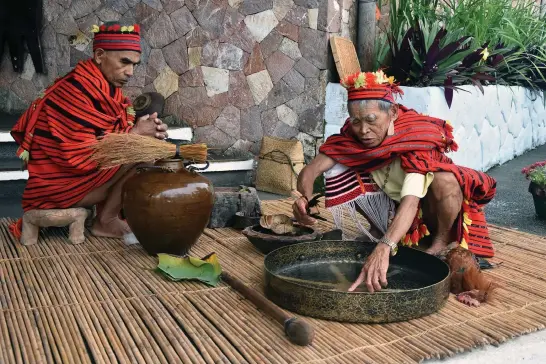  ?? Photo by Redjie Melvic Cawis ?? IFUGAO RITUAL. Two Mumbaki (native priests) perform traditiona­l Ifugao rituals during the Cordillera Unity Gong Relay kick off program at the Banaue Hotel in Ifugao. The gong relay was conceived by the RDC to help draw all the provinces and the City of...