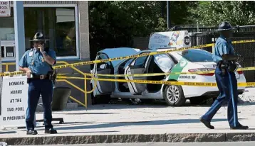  ??  ?? Standing guard: Massachuse­tts state police officers at the crash site near the Logan Internatio­nal Airport in Boston. — Reuters