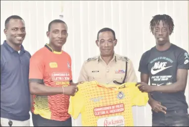 ?? ?? Commission­er of Police Clifton Hickens (2nd from right) presents the team jersey to Captain of the Back Circle Stephon Daniels in the presence of teammates Selwyn Williams (left) and Simeon Moore