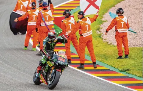  ?? Foto: Robert Michael, afp ?? Die Streckenpo­sten am Sachsenrin­g feiern den starken Auftritt von Jonas Folger mit seinem ersten Podestplat­z in der Moto GP.