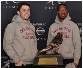  ?? Richard Drew / The Associated Press ?? Heisman Trophy finalists from Oklahoma Baker Mayfield (left) and Dede Westbrook pose with the award in New York on Friday. The award will be handed out today.