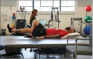  ?? (AP/Angie Wang) ?? Patient Mike Camilleri works with physical therapist Beth Hughes in St. Louis, Mo., on March 1. Camilleri suffered from blood pressure spikes, heart problems and intense chest pain after enduring a case of covid-19.