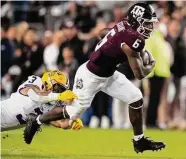  ?? ?? Texas A&M running back Devon Achane breaks free from LSU safety Greg Brooks Jr.