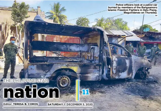  ?? AP ?? Police officers look at a patrol car burned by members of the Bangsamoro Islamic Freedom Fighters in Datu Piang, Maguindana­o on Thursday.