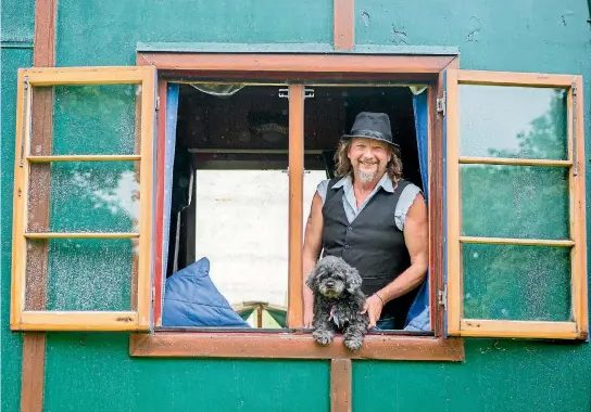  ?? TOM LEE/STUFF ?? Ian Mailman and Dave the lhaso apso-shih tzu-cross have all they need in the house truck, including a potbelly stove, hammock, solar panels, and greywater waste tanks.