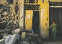  ?? FELIPE DANA/THE ASSOCIATED PRESS ?? Samaher Saddam cleans the entrance of her damaged house Thursday in Mosul, Iraq. The fight to defeat the Islamic State in Mosul ended in devastatio­n.