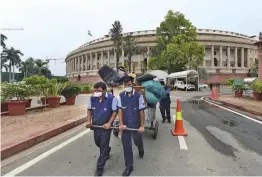  ?? — PTI ?? Workers pull a cart laden with discarded materials a day before the monsoon session of Parliament in New Delhi on Sunday.