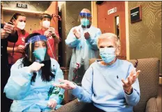  ?? Stephen Dunn / Associated Press ?? Confetti flies in the air Friday as Jeanne Peters, 95, gestures after she was given the first COVID-19 vaccinatio­n at The Reservoir, a nursing facility in West Hartford. Mary Lou Galushko, left, looks on.