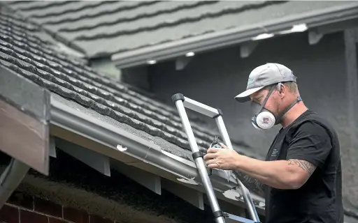  ?? JOHN BISSET/STUFF ?? Building inspector Craig O’Keefe is concerned dust from asbestos-containing tiles may have become scattered on public footpaths through the hailstorm and cleanup operations.