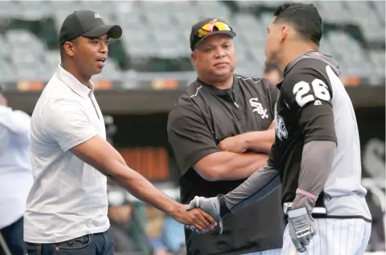  ?? | CHARLES REX ARBOGAST/ AP ?? Eloy Jimenez, who has been playing at Class AA Birmingham, shakes hands with Avisail Garcia as Sox hitting coach Todd Steverson looks on Tuesday.
