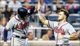  ?? ELSA / GETTY IMAGES ?? Atlanta’s Freddie Freeman (left) and Adam Duvall celebrate after they scored against the Mets earlier this month in New York.