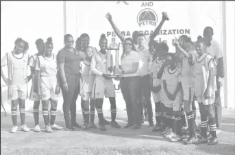  ??  ?? The victorious Charlestow­n girls team collects their trophy from the ExxonMobil Senior Director, Public and Government Affairs Deedra Moe following their win over East La Penitence.