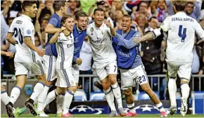  ??  ?? You beauty: Ronaldo is mobbed by his jubilant Madrid team-mates