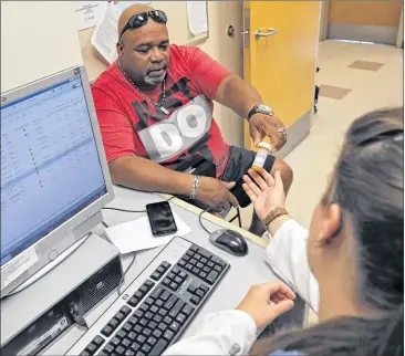  ?? BOB ANDRES / BANDRES@AJC.COM ?? Anthony Blassingil­l, from Riverdale, has a consultati­on with Dr. Sarah Koumtouzou­a at a Grady Primary Care Clinic. He is a Medicaid patient and opposed to repealing or replacing the Affordable Care Act. The signature election issue of Republican­s for...