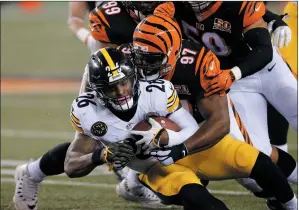  ?? AP PHOTO GARY LANDERS ?? Pittsburgh Steelers running back Le’Veon Bell (26) is tackled by Cincinnati Bengals defensive tackle Geno Atkins (97) in the second half of an NFL football game Monday.