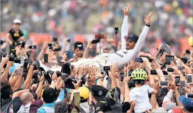  ??  ?? FELICIDAD. Lewis Hamilton celebró con los aficionado­s del circuito de Silverston­e su cuarta victoria del año que le sitúa a un punto de Sebastian Vettel en el Mundial de pilotos.