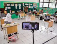  ?? DIPTA WAHYU/JAWA POS ?? DUDUK MANIS: Guru mendamping­i murid kelas VI SDN Ketintang 2 Surabaya mengikuti simulasi pembelajar­an tatap muka kemarin.