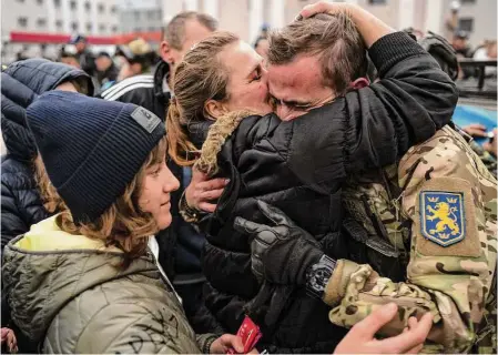  ?? Lynsey Addario/New York Times ?? Civilians greet Ukrainian soldiers Saturday after the liberation of Kherson when Russia announced it had retreated. Ukrainian soldiers were working to secure the city amid fighting on its outskirts. Humanitari­an groups were poised to bring in aid.