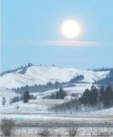  ?? TED RHODES ?? The full moon rises over the Trans-canada Highway and the Stoney reserve. The Stoney Nakoda First Nation is using a variety of ways to communicat­e info about the dangers of COVID-19 to community members, and is delivering those messages in both Stoney and English.