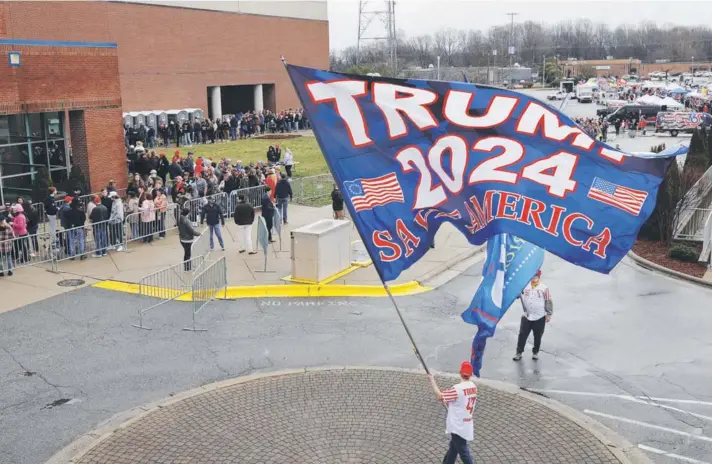  ?? ?? ►
Un partidario del ex presidente Donald Trump ondea una bandera mientras los asistentes a un mitin hacen fila en Greensboro, Carolina del Norte, , el 2 de marzo de 2024.